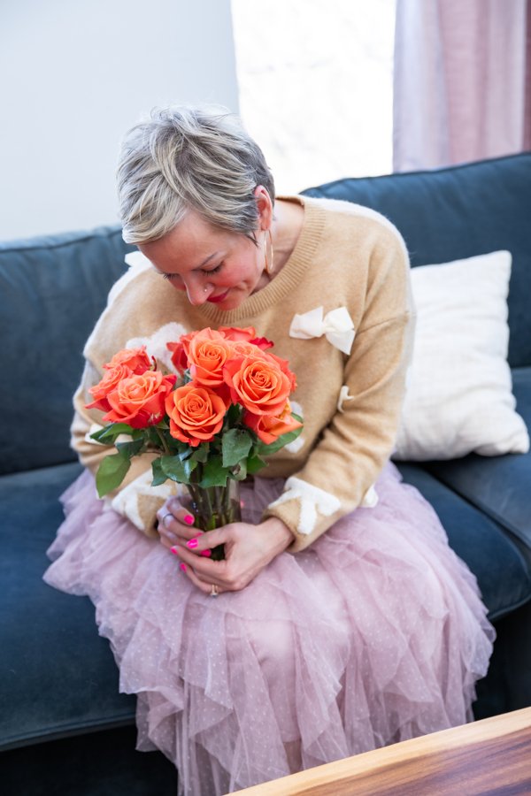 Renee DeVore, holding a bouquet of orange roses
